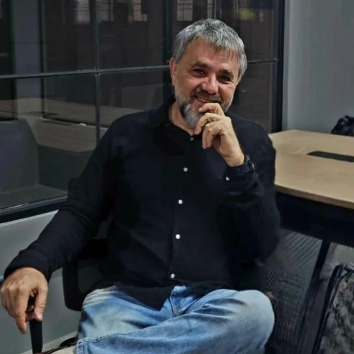 Marcus Sperb, fundador da InnovaAI, sentado à mesa do escritório.